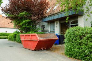 Uncollected skip waiting to be filled outside a driveway
